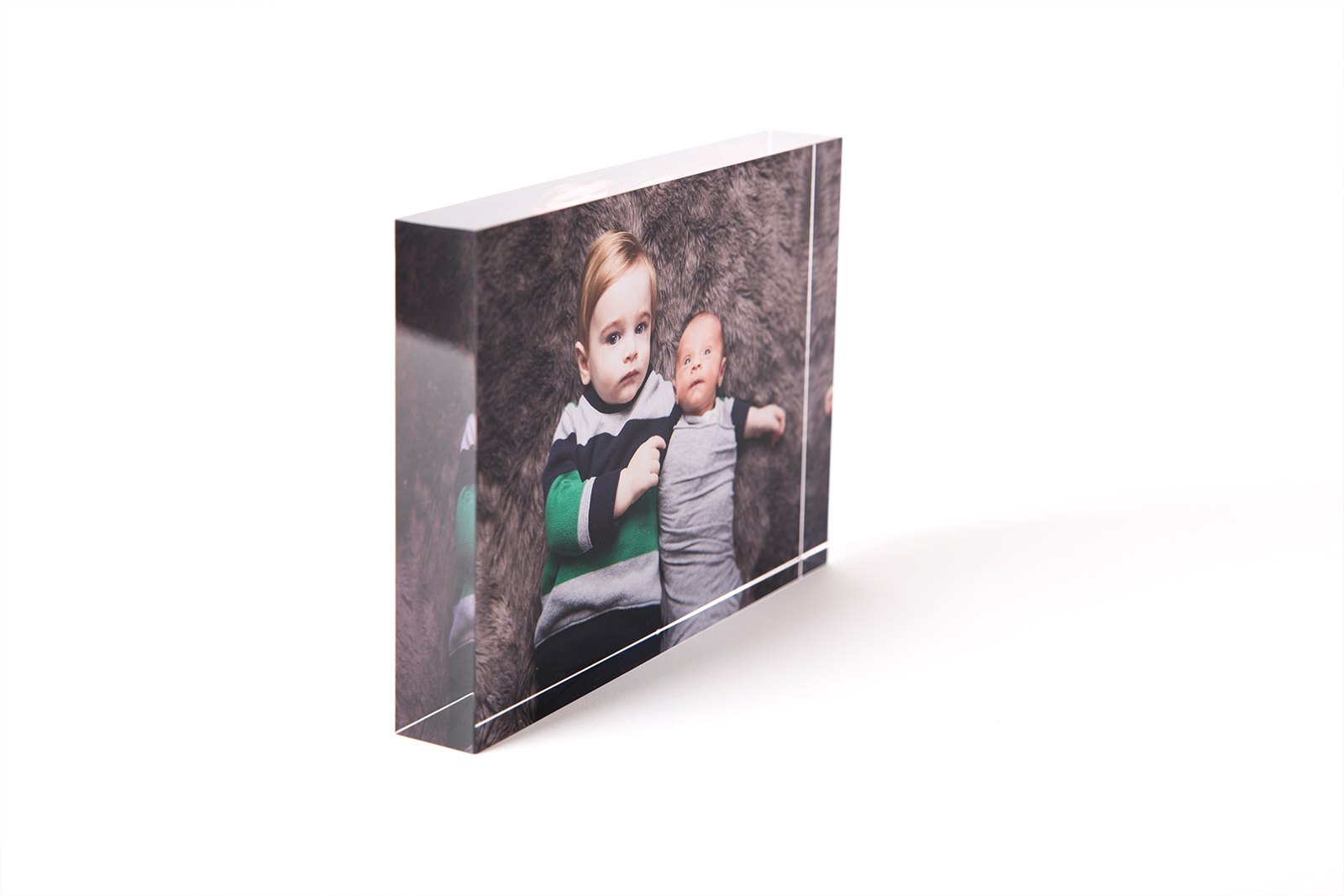 side view of acrylic block of brother holding baby on top of brown flokati with stoke photography gift box