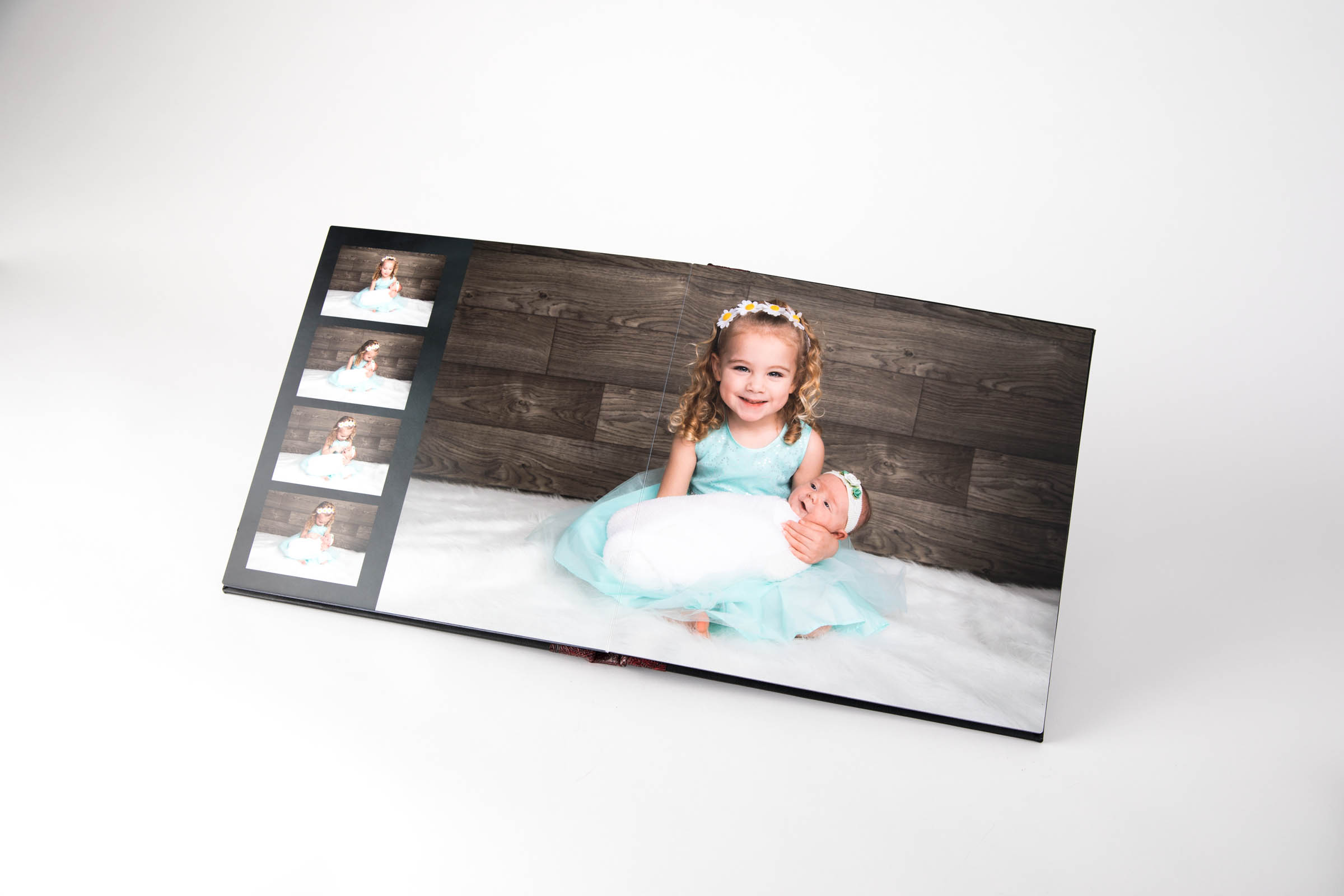 Beautiful luxe heirloom album showing the inside pages of a big sister wearing turquoise dress holding baby sister 