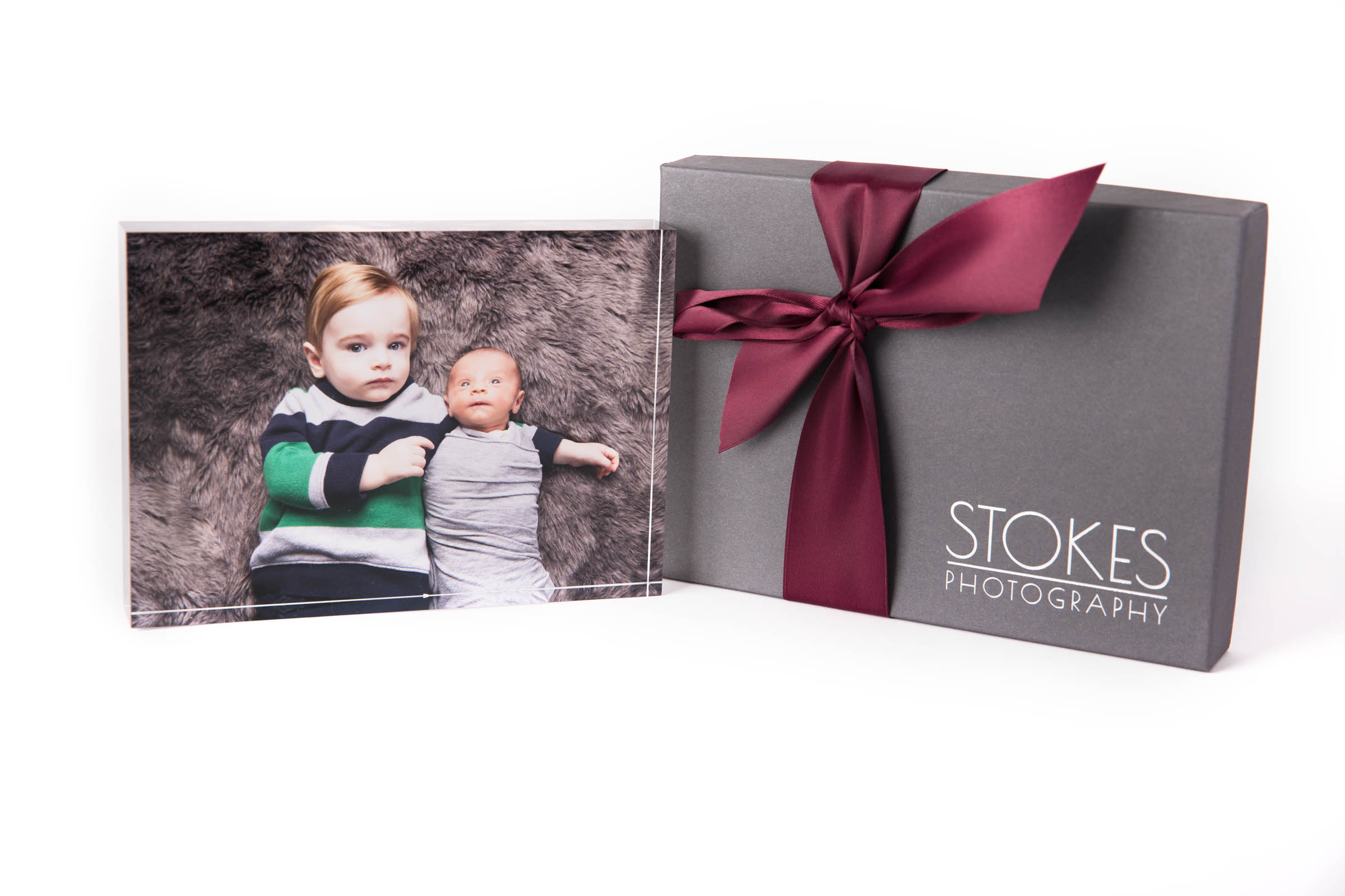 Beautiful acrylic block of brother holding baby on top of brown flokati with stoke photography gift box