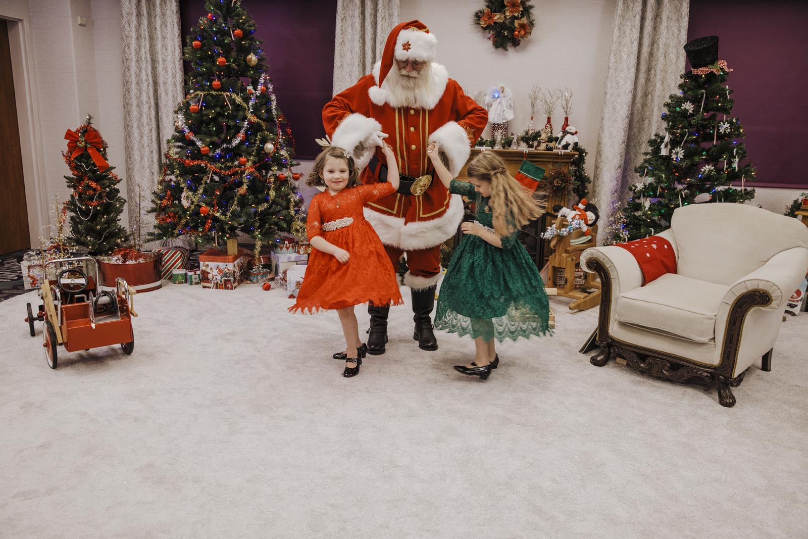 boise santa pics santa dancing with two little girls in fancy dresses twirling around